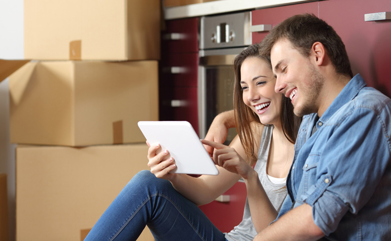 Couple sitting on floor surrounded by moving boxes